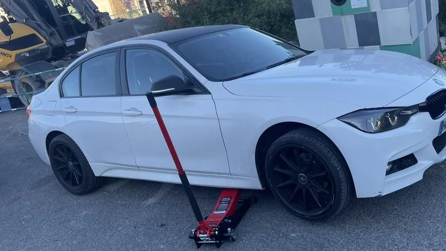 Montage de pneus a domicile sur berline BMW blanche a Lyon avec cric hydraulique professionnel, atelier mobile Assist'Pneu24